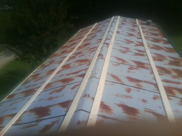 Rusted metal roof panels with new wood purlins before replacement — Storm Damage Roof Repair in Northville by Roofing Brothers