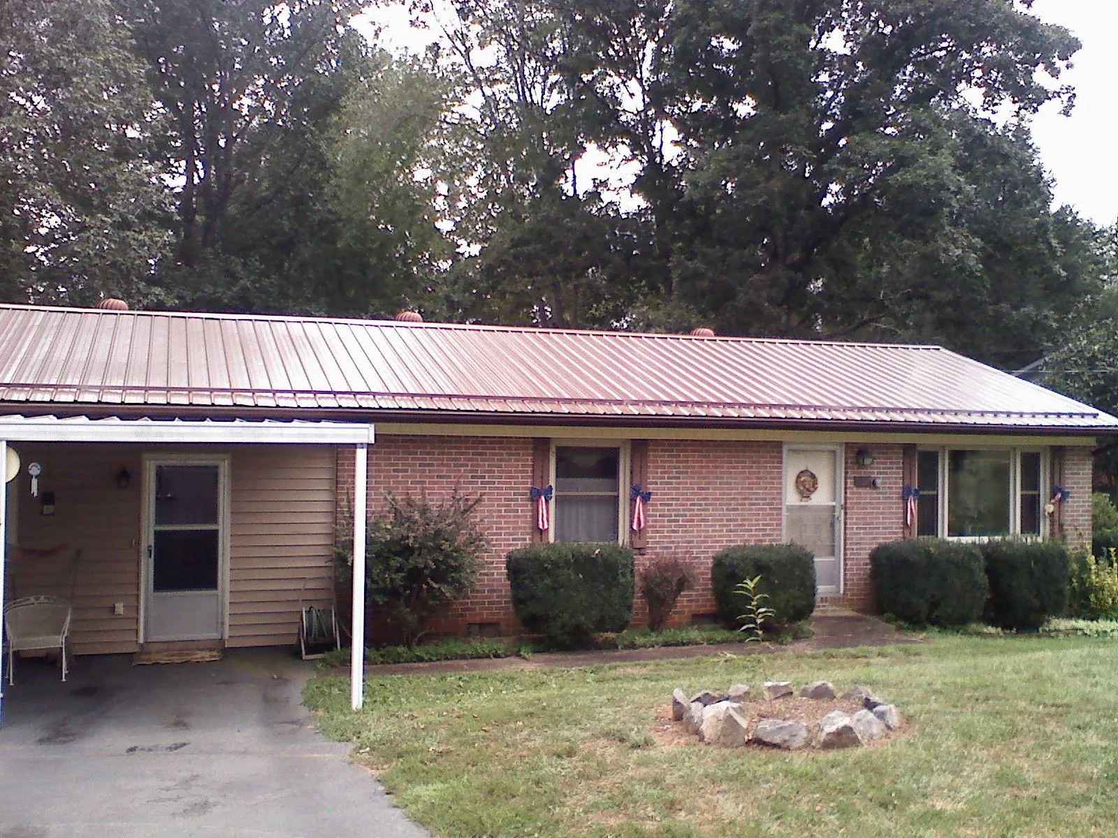 Bronze metal roof and carport on a brick ranch home — Roof Repair work by our crew in Northville